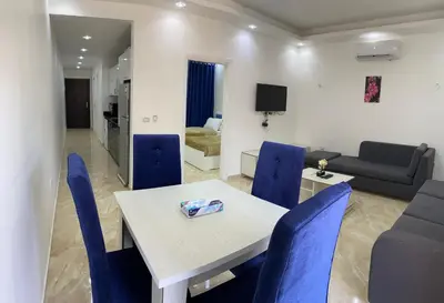 a living room with a table and blue chairs at selena bay in Hurghada