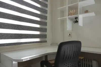 a desk with a chair next to a window with blinds at Private 1 bedroom flat with garden in Makadi in Hurghada