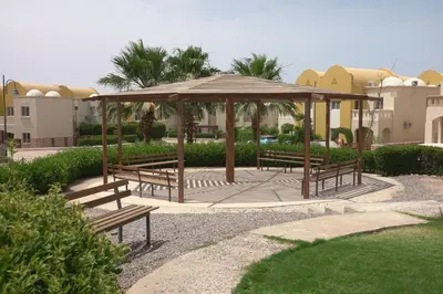 a gazebo with benches in a park at Private 1 bedroom flat with garden in Makadi in Hurghada