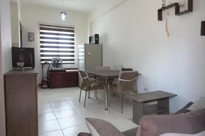 a living room with a table and chairs and a refrigerator at Private 1 bedroom flat with garden in Makadi in Hurghada