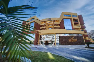 a building with a palm tree in front of it at New Eagles Downtown Zahabia Resort & Aqua Park in Hurghada