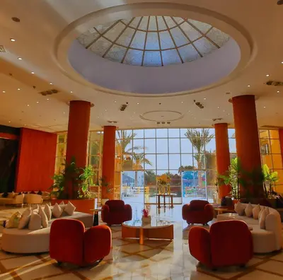a lobby with couches and chairs and a glass ceiling at New Eagles Downtown Zahabia Resort & Aqua Park in Hurghada