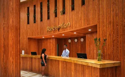 a woman standing at the reception desk of a hotel at New Eagles Downtown Zahabia Resort & Aqua Park in Hurghada