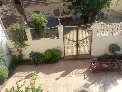 an empty courtyard with a gate and a bench at Masa House Luxor in Luxor