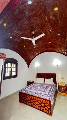 a bedroom with a large bed with a ceiling at Masa House Luxor in Luxor