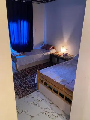 a bedroom with two beds and a blue curtain at hooly nubian in Aswan