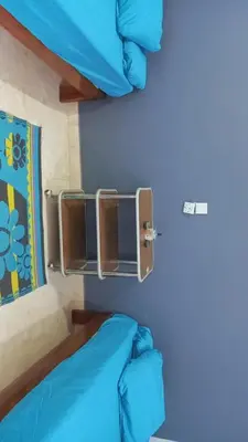 a bed in a room with a blue wall at Rema Nubian Guest House in Aswan