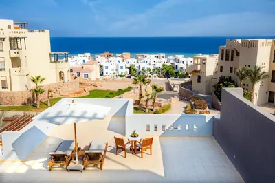 a view of the beach from the balcony of a building at AJIRA Resort Sahl Hasheesh in Hurghada