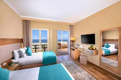 a hotel room with two beds and a television at AJIRA Resort Sahl Hasheesh in Hurghada
