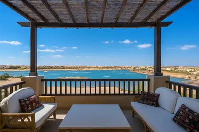 a balcony with couches and a table and a view at Lagoon View Penthouse - El Gouna Paradise Escape in Hurghada