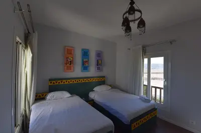 two beds in a room with a window at Lagoon View Penthouse - El Gouna Paradise Escape in Hurghada