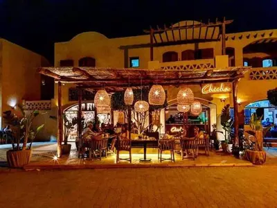 a group of people sitting at a restaurant at night at Lagoon View Penthouse - El Gouna Paradise Escape in Hurghada