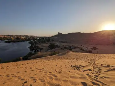 a view of a desert with a river and the sunset at Nile View Guest House in Aswan