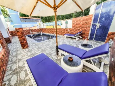 a patio with purple chairs and an umbrella at Sunshine House in Luxor