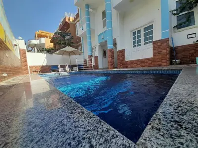 a swimming pool in front of a house at Sunshine House in Luxor