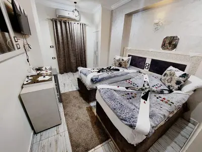 a small room with two beds and a table at Al Amir Palace Hotel in Suwhaj