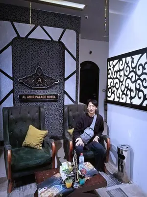 a man sitting in a chair in a room at Al Amir Palace Hotel in Suwhaj