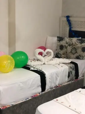 two twin beds with balloons on top of them at Al Amir Palace Hotel in Suwhaj