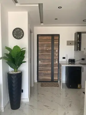 a kitchen with a clock on the wall and a plant at Blue Whale Hurghada Beach Front Apartments City Centre in Hurghada