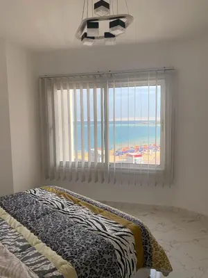 a bedroom with a window with a view of the beach at Blue Whale Hurghada Beach Front Apartments City Centre in Hurghada