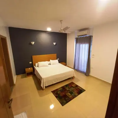 a bedroom with a white bed and a blue wall at Ali Luxury Villa in Luxor