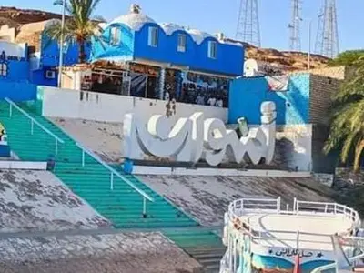 a blue and white building with stairs and a boat at Noura hasel nubian house in Aswan