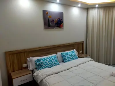 a bedroom with a bed with blue and white pillows at شقة علي البحر 2 in Hurghada