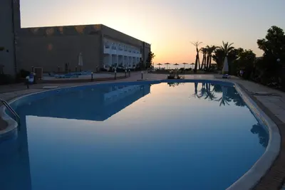 a large swimming pool with blue lighting in front of a building at Compound cecelia in Hurghada