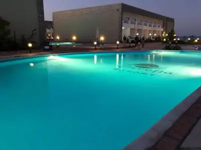 a large pool with blue lights in front of a building at Compound cecelia in Hurghada