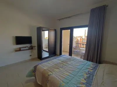 a bedroom with a bed and a sliding glass door at Aldau Heights lovely studio in Hurghada