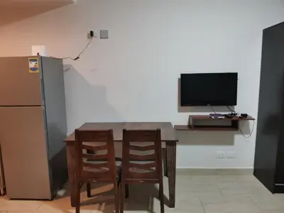 a kitchen with a table and two chairs and a television at Aldau Heights lovely studio in Hurghada