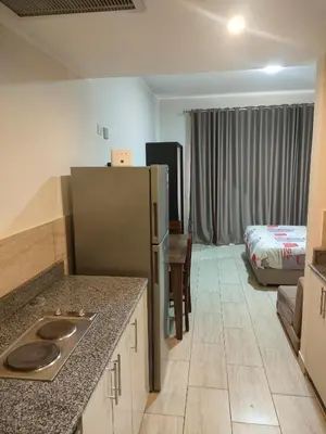 a kitchen with a refrigerator and a room with a bed at Aldau Heights lovely studio in Hurghada