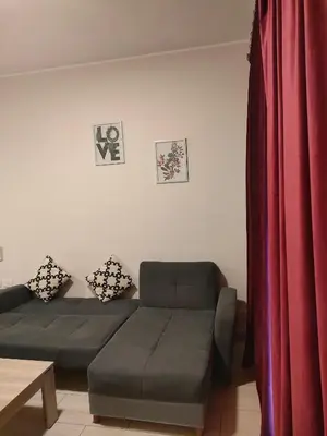 a living room with a couch and a red curtain at Aldau Heights Cozy big studio in Hurghada