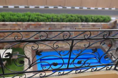 a wrought iron railing on a balcony with plants at Royal Mountain in Luxor