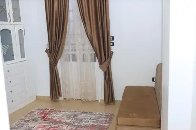 a room with a window with curtains and a rug at Royal Mountain in Luxor