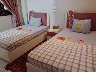 two beds with hello kitty pillows in a bedroom at Cattleya Guesthouse in Aswan