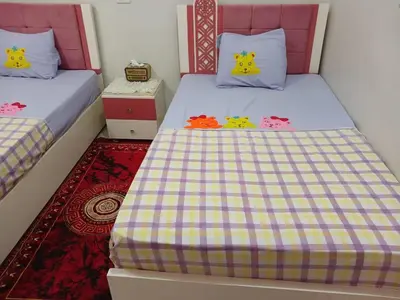 two beds with hello kitty pillows in a bedroom at Cattleya Guesthouse in Aswan