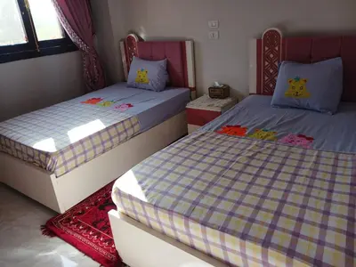 two beds in a small room with two bedsitures at Cattleya Guesthouse in Aswan