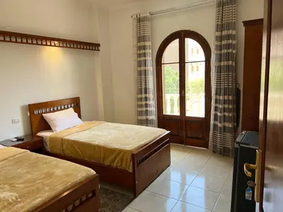 a bedroom with two beds and a window at Mikhaila Guest House in Luxor