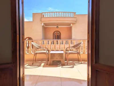 a patio with two chairs and a table on a balcony at Mikhaila Guest House in Luxor