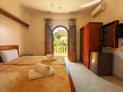 a bedroom with two beds and an open window at Mikhaila Guest House in Luxor