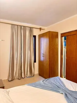 a bedroom with a bed and a wooden cabinet at Snorkeling Paradise 5 Star Resort Stella Makadi in Hurghada