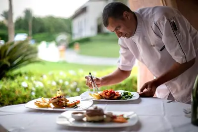 a chef preparing plates of food on a table at Snorkeling Paradise 5 Star Resort Stella Makadi in Hurghada