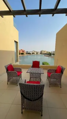 a patio with tables and chairs with a view of the water at Luxury 3BR Townhouse, Tawila, El Gouna, Lagoon & Pool access in Hurghada