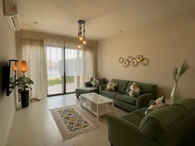 a living room with two green couches and a table at Luxury 3BR Townhouse, Tawila, El Gouna, Lagoon & Pool access in Hurghada