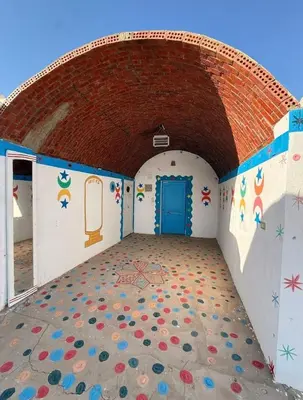 a room with a door and a wall with graffiti at Nubian Wessy Ka Guest House in Aswan