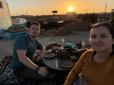a man and a woman sitting at a table with food at Nubian Wessy Ka Guest House in Aswan