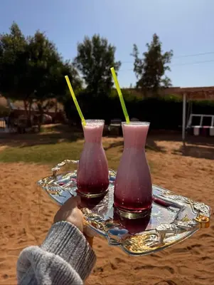 two glass vases on a tray on the beach at Nubian Wessy Ka Guest House in Aswan