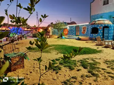 a resort with a table and chairs on the beach at Nubian Wessy Ka Guest House in Aswan