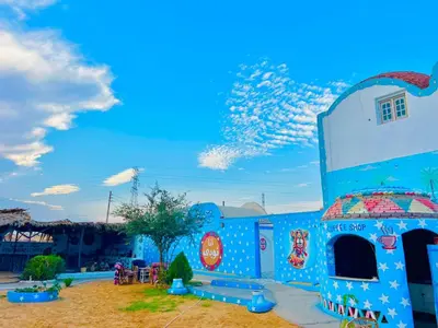a blue building with a sky in the background at Nubian Wessy Ka Guest House in Aswan